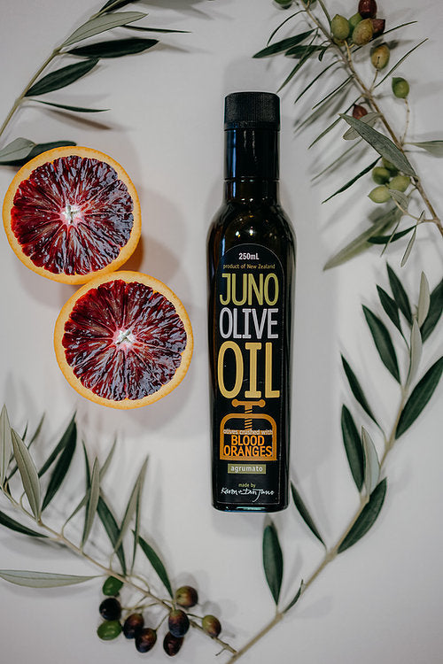 250 mL dark green bottle of Blood Orange agrumato oil, surrounded by olive brances and blood oranges.