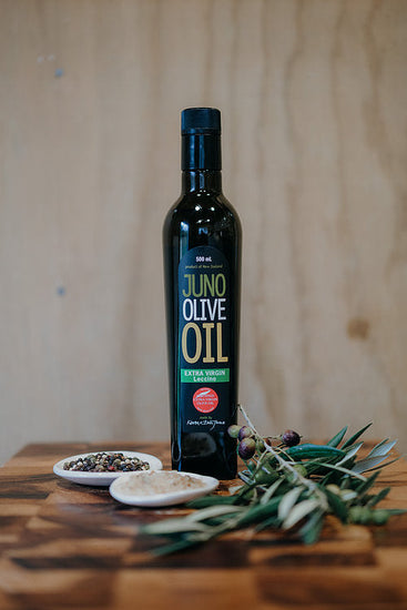 Dark green bottle of Juno Olive Oil. Leccino Variety