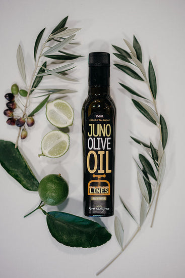 250 mL dark green bottle of Lime agrumato oil, surrounded by olive brances and limes.