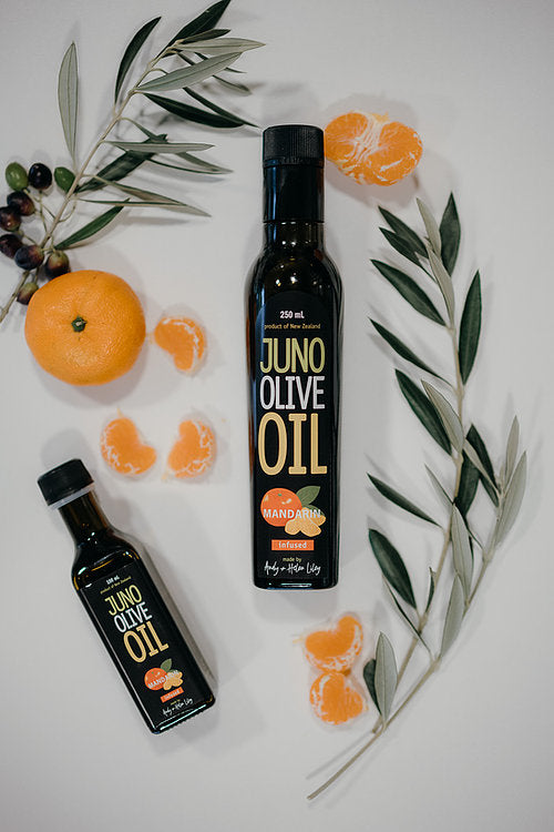 100 and 250 mL dark green bottles of Mandarin Infused Olive oil. Mandarins and Olive leaves surrounding